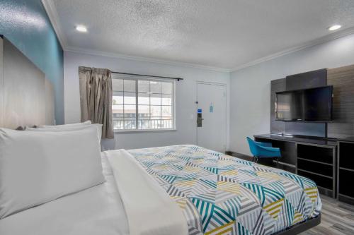 圣贝纳迪诺Studio 6 Suites San Bernardino, CA的一间卧室配有一张床和一台平面电视