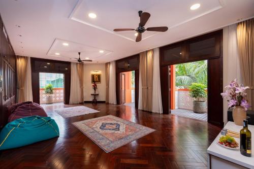 头顿OrangeBlue villa near Beach Pool free Vung Tau Vietnam的客厅配有吊扇,铺有木地板。