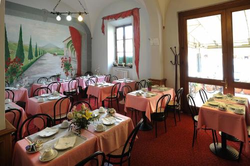 比萨金兹卡别墅酒店的用餐室配有桌椅和粉红色的桌布
