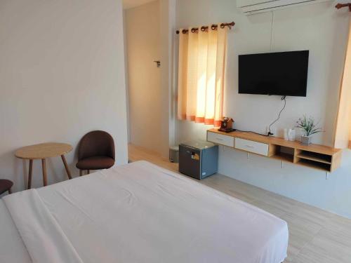 Ban Mae Laiกุหลาบแก้ว รีสอร์ท的一间卧室配有一张床和一台平面电视