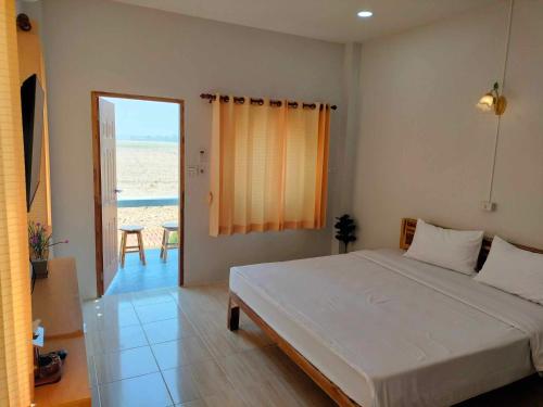 Ban Mae Laiกุหลาบแก้ว รีสอร์ท的一间卧室配有一张床,享有海滩美景