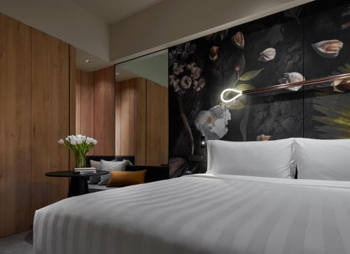 吉隆坡吉隆坡宾乐雅臻选酒店的一间卧室设有一张床和鲜花墙