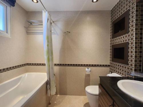芭堤雅市中心D34长住优惠房-芭提雅市中心高端4间卧室泳池别墅的带浴缸、卫生间和盥洗盆的浴室