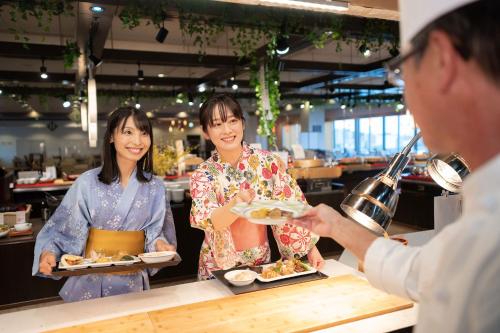 加贺Ooedo Onsen Monogatari Nagayama的给女人一盘食物的男人