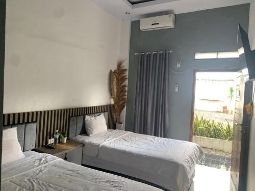 班达楠榜Oemah Ratu Hostel Syariah RedPartner的一间卧室设有两张床和一个美景窗户。