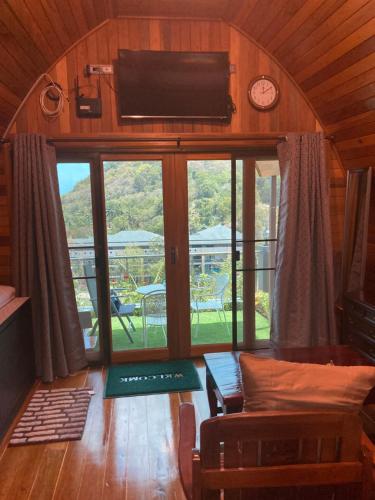 拉威海滩Seaview Eagles Nest Cabins的客厅设有大窗户和电视。