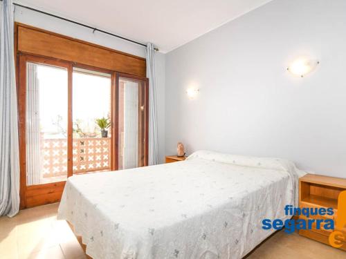 罗达德瓦拉Apartamento Roda de Berà, 3 dormitorios, 6 personas - ES-320-5的一间卧室设有一张大床和一个大窗户