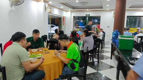 顺化Dat Anh Hotel的一群坐在餐桌上吃食物的人