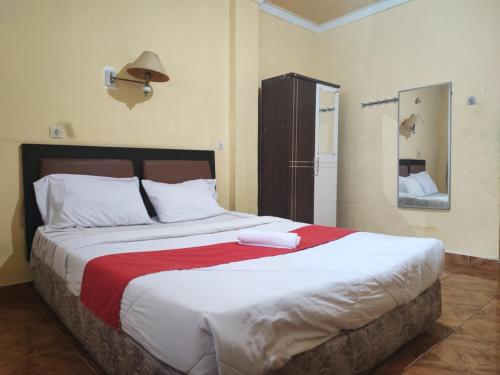 占碑市RedDoorz Syariah At Hotel Matahari 1 Jambi的一间卧室配有一张带红色毯子的大床