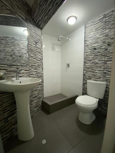 瓦拉斯Wayra Hotel的浴室配有白色卫生间和盥洗盆。
