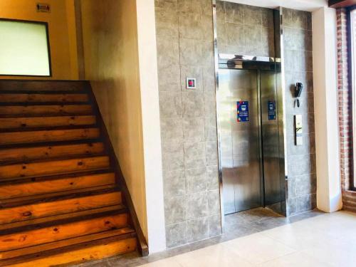 奥隆阿波Mango Valley Hotel 5的一座带木楼梯的建筑中的电梯