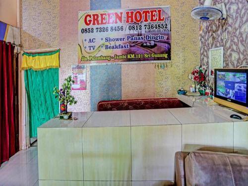 占碑市OYO 92024 Green Hotel的墙上有绿色酒店标志的房间