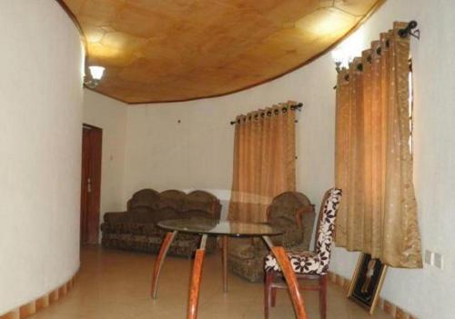 AgbabiakaAdap Hotel的客厅配有桌子和沙发