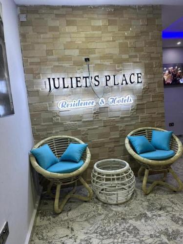 EregunJuliet's Place Residence & Hotel的商店前的两把椅子和蓝色枕头