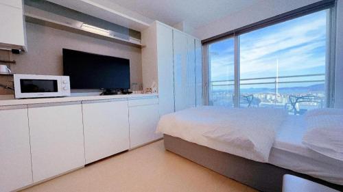 仁川市Yeongjong Shine Hotel的一间卧室设有一张床铺、微波炉和大窗户