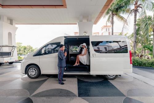 曼谷曼谷素万那普艾美高尔夫水疗度假酒店的站在白色货车后面的新娘和新郎