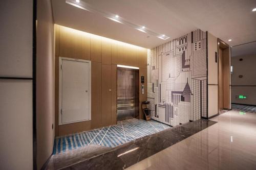 QuelingzuiCity Comfort Inn Ezhou Wuyue Plaza的走廊上挂有墙,画着建筑物的图纸