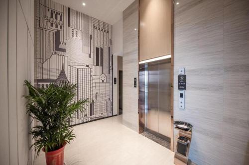 QuelingzuiCity Comfort Inn Ezhou Wuyue Plaza的电梯大厅,楼里有盆栽植物