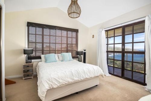 KioloaOcean Shores Waterfront 5 Bedroom Home Including SAUNA room的一间卧室设有一张床和一个大窗户