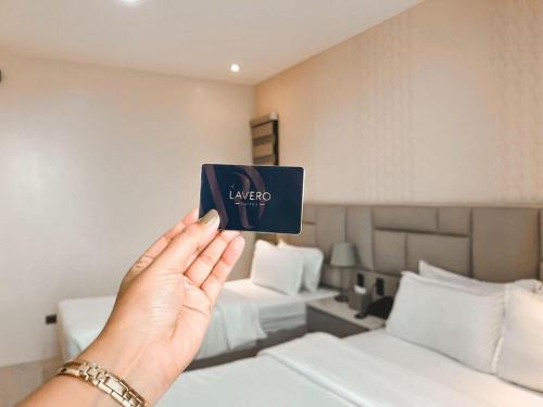 卡利博LAVERO SUITES的一个人在旅馆房间持有一张蓝色卡