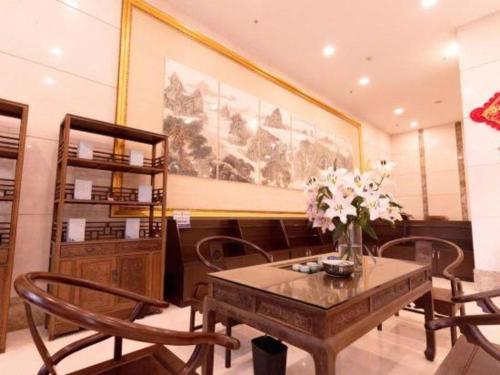 HeshanBashan Hotel的一间带桌椅和绘画的用餐室