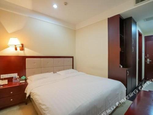 HeshanBashan Hotel的卧室配有一张白色大床和一张书桌