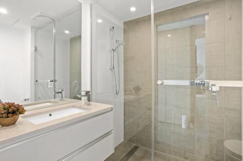 布里斯班Executive 2-Bed with Stadium View, Great Amenities的一间带水槽和玻璃淋浴的浴室
