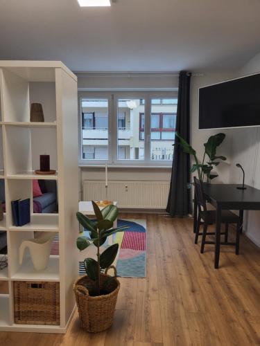 新乌尔姆ALA Living Stadt-Schwärmer Apartment 10min zum Ulmer Münster & Ulmer Altstadt, WLAN & Arbeitsplatz的客厅配有桌子和窗户