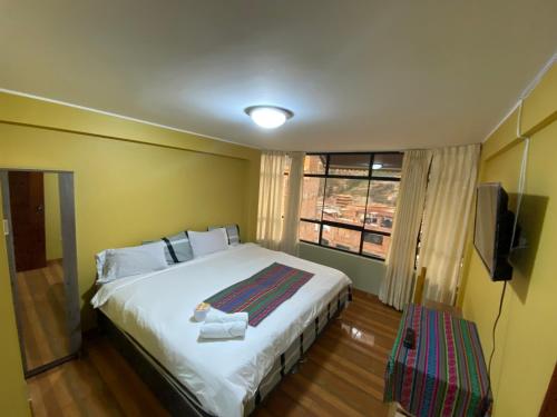 瓦拉斯Wayra Hotel的一间卧室设有一张大床和一个窗户。