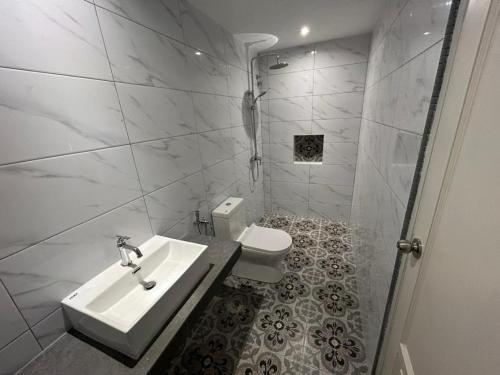 怡保The Farmhouse的白色的浴室设有水槽和卫生间。