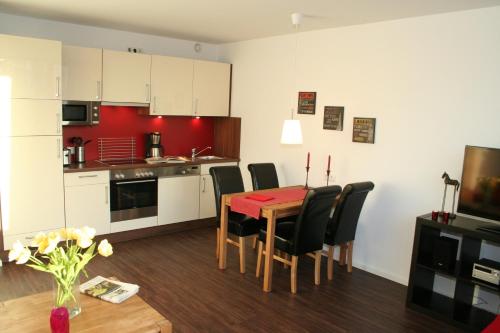 汉堡南运河公寓式酒店的厨房以及带桌椅的用餐室。