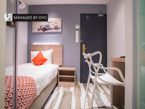 科塔达曼萨拉Super OYO GS Hotels Near Strand Mall的一间小卧室,配有一张床和一把椅子