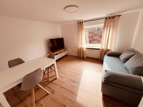 明登Ferienwohnung/Monteurwohnung Souterrain, neu renoviert的带沙发、桌子和电视的客厅