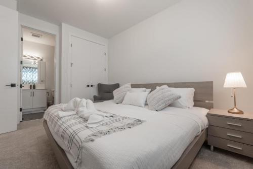 卡尔加里Room 2 of Lovely home, Montgomery downtown Calgary的白色卧室设有一张大床和一盏灯。