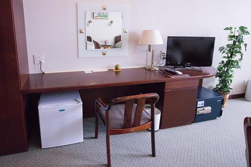 都城市ホテル中山荘的一张桌子,一张桌子,一台电脑和一把椅子放在一个房间里