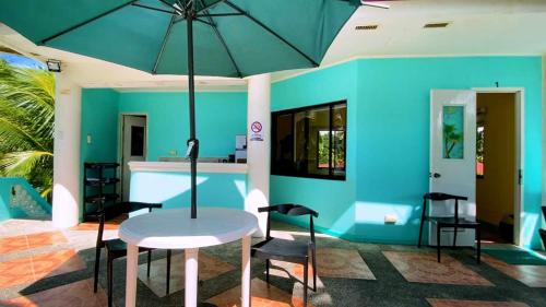 潘丹L&L Beach Resort的蓝色的房间,配有桌椅和雨伞