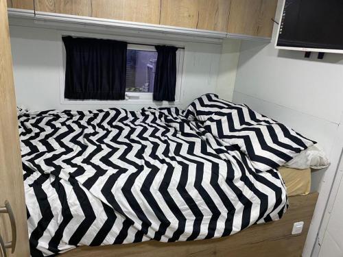 赖阿南纳קראוון ברעננה的黑白的被子,放在房间里的床边