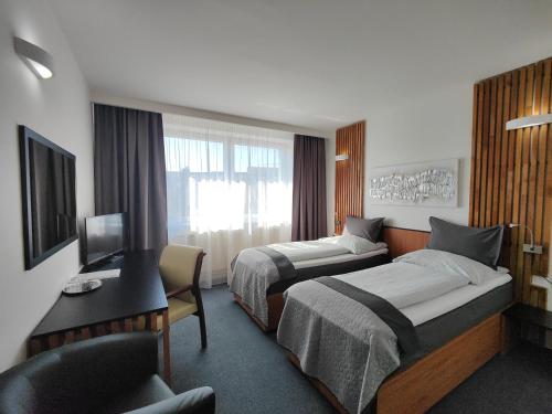 卢切内茨Hotel P7的酒店客房配有两张床和一张书桌