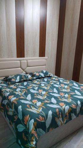 瓦拉纳西Preet Home Stay的一张带鲜花的蓝色棉被的床