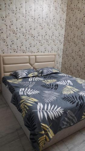 瓦拉纳西Preet Home Stay的一张带蓝色棉被和枕头的床