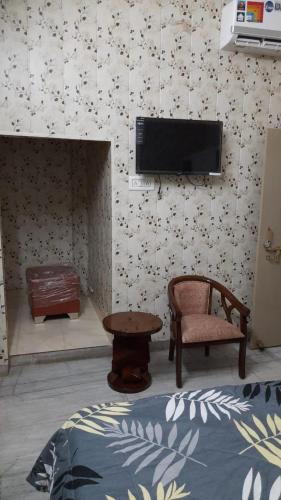 瓦拉纳西Preet Home Stay的配有电视、椅子和桌子的房间