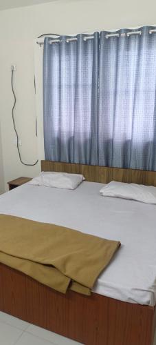 辛加瓦迪Akshra residency 1 bhk的一间卧室配有床和窗帘