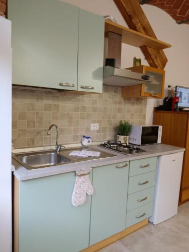 佩夏Casa in Bocca al Fiume的厨房配有白色橱柜和水槽