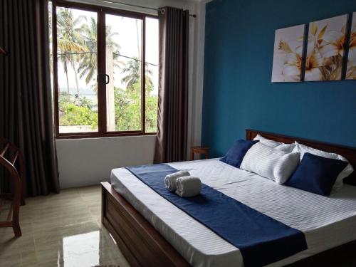 库鲁内格勒LEO-BREEZE Apartments的一间卧室配有一张蓝色墙壁的床和一扇窗户