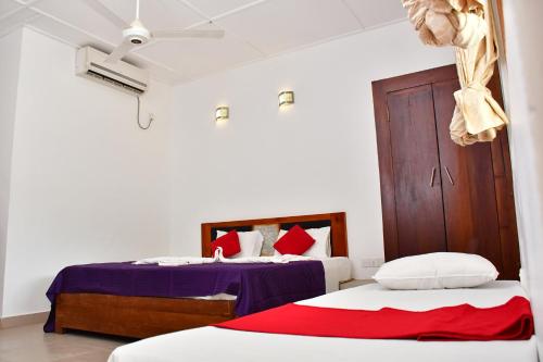 尼拉瓦利Sea Way Hotel的一间卧室设有两张床和木门
