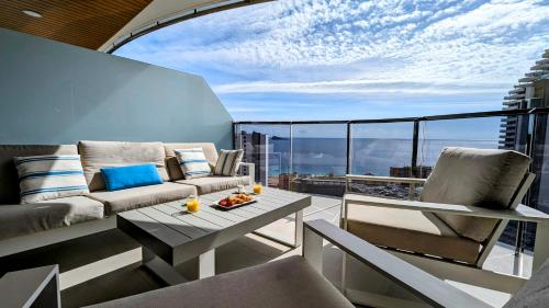 贝尼多姆SUNSET WAVES luxury apartment的客厅配有沙发和阳台桌子