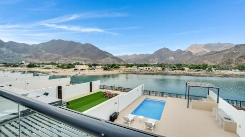 富查伊拉Al Dana Paradise Luxury Villas Palm Fujairah Sea View的享有水景和山景的阳台