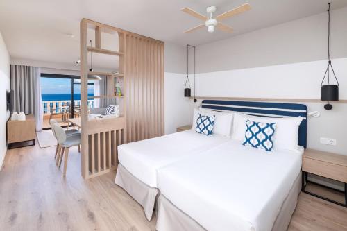 阿德耶阳光海滩公寓的一间卧室配有一张床,享有海景