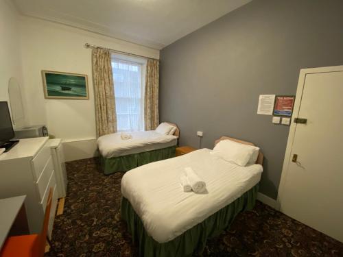 阿伯丁Aaran Central Guesthouse的酒店客房设有两张床和窗户。