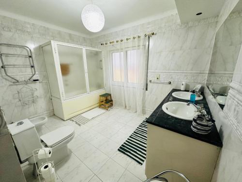 蓬塔德尔加达DMCharme的白色的浴室设有水槽和卫生间。